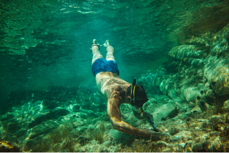A man snorkeling and explore shallow waters on Komodo